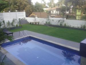a swimming pool in the backyard of a house at Ocean Shores Hospitality in Candolim