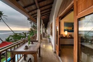 uma varanda com mesas e vista para o oceano em Villa Océane em Mirissa