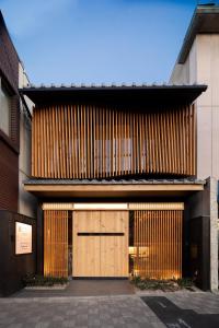 um edifício com portas de madeira e um edifício em Tsumugi Tojihigashimonmae em Quioto