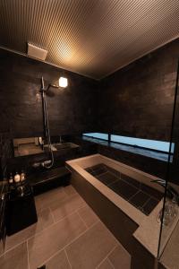 uma casa de banho com uma banheira e um lavatório em Tsumugi Tojihigashimonmae em Quioto