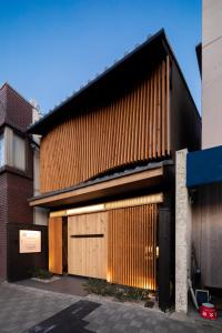 um edifício com portas de garagem de madeira numa rua em Tsumugi Tojihigashimonmae em Quioto