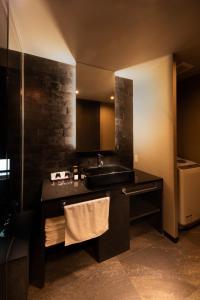uma casa de banho com um lavatório e um balcão com uma toalha em Tsumugi Tojihigashimonmae em Quioto