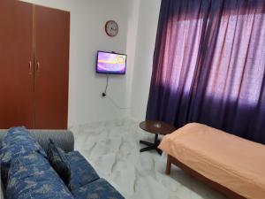 - une chambre avec un lit et une télévision murale dans l'établissement Sami Apartments, à Amman