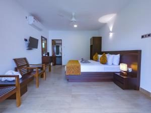 um quarto de hotel com uma cama, uma mesa e cadeiras em Bony's Holiday Inn Negombo em Negombo