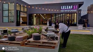 Eine Frau, die sich vor einem Gebäude über einen Tisch beugt. in der Unterkunft U pool villa Huahin in Hua Hin