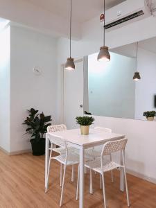 a white dining room with a white table and chairs at SENJA Homes in Kuala Terengganu