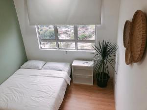 a small room with two beds and a window at SENJA Homes in Kuala Terengganu