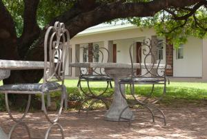 a table and chairs sitting under a tree at Olden Rose Place in Lephalale