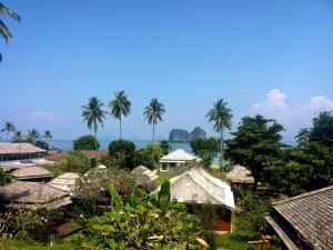 a view of a village with palm trees and the ocean at Thanya Beach Resort - SHA Plus in Ko Ngai