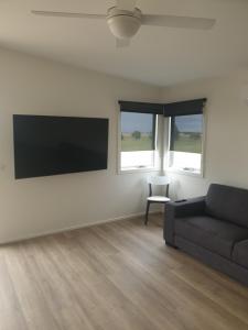 a living room with a couch and a flat screen tv at Lara Lodge in Lara