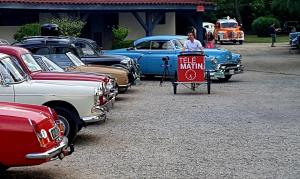 a man standing behind a sign in front of a row of cars at Relais 500 De Vienne in Chonas-lʼAmballan