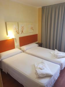 a hotel room with two beds and a window at Apartamentos Parot Quality in Santa Eularia des Riu
