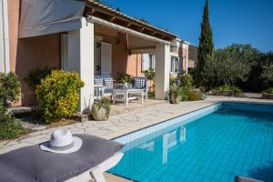 een villa met een zwembad en een hoed op een tafel bij Villa Oleander in Áfra