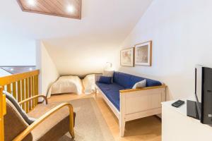 a living room with a blue couch and a tv at Levitori 3 in Levi
