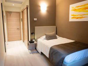 a bedroom with a bed and a hallway with a door at Helios Hotel & Restaurant in Monza