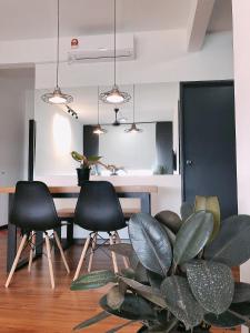 un comedor con 3 sillas, una mesa y una planta en TEDUH Residence, en Kuala Terengganu