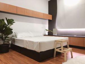 1 dormitorio con cama grande y taburete de madera en TEDUH Residence, en Kuala Terengganu