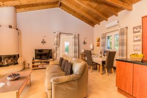 uma sala de estar com um sofá e uma mesa em Villa Oleander em Áfra
