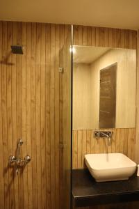 a bathroom with a sink and a mirror at Mangal Grand Hotel in Beāwar
