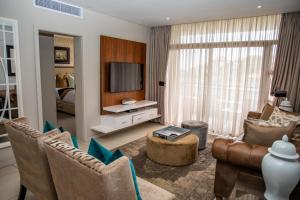 a living room with a couch and chairs and a television at Zimbali Suite 414 in Ballito