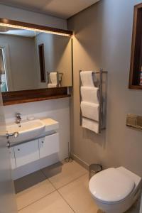 a bathroom with a toilet and a sink and a mirror at Zimbali Suite 414 in Ballito