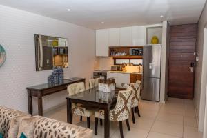 a kitchen and dining room with a table and chairs at Zimbali Suite 414 in Ballito