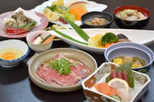 une table recouverte de bols de différents types de denrées alimentaires dans l'établissement Dai Onsen Matsudaya Ryokan, à Hanamaki