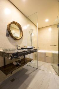 a bathroom with a sink and a mirror and a tub at Fu Yuan Tan Villa in Fuyuan