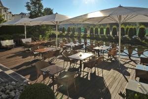 a restaurant with tables and umbrellas on a deck at COURT HOTEL in Halle Westfalen