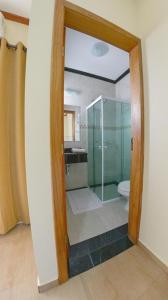 a bathroom with a glass shower and a toilet at Rohedama Hotel in Guaratinguetá