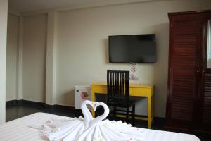 two white swans sitting on a bed in a room at Le Water Villa in Siem Reap