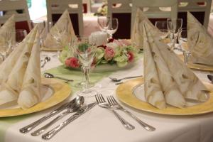 a table with plates and silverware on top of it at Hotel & Restaurant Park Cafe ISA in Erfurt