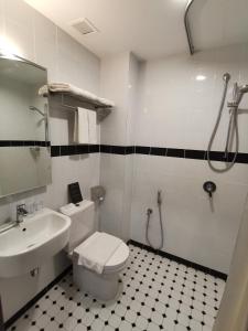 a bathroom with a toilet and a sink and a shower at Kimberley Hotel Georgetown in George Town
