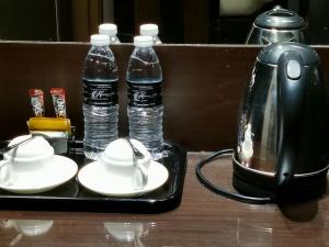 a tray with two bottles of water and a tea kettle at Kimberley Hotel Georgetown in George Town