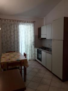 eine kleine Küche mit einem Tisch, einem Tisch und einem Tisch in der Unterkunft Appartamento Federica in Valledoria
