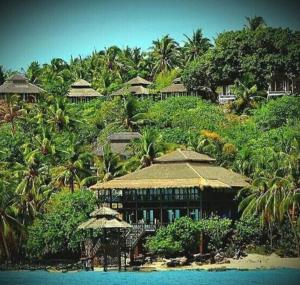 a resort on a hill with trees and blue water at Breve Azurine Lagoon Resort in Karimunjawa
