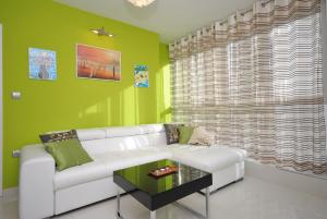 a living room with a white couch and a green wall at Apartment Antea in Split