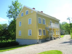 una casa amarilla en un camino de grava en Gustafsbergs Badhotell & Vandrarhem, en Uddevalla