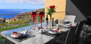 Una mesa con copas de vino y vista al océano. en Madeira Mar - Seaview, en Funchal