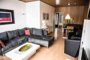 un soggiorno con divano nero e tavolo di Feriehaus Maple Leaf a Willingen