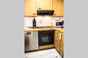 a kitchen with stainless steel appliances and wooden cabinets at Feriehaus Maple Leaf in Willingen