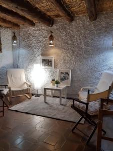 a living room with chairs and a table and a wall at Lo Cremallé in Valderrobres
