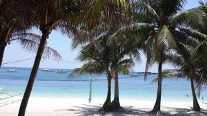 a group of palm trees on a beach with the ocean at Marnin's Place in Boracay