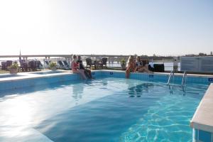 a group of people sitting on the edge of a swimming pool at SUNRISE Semiramis I Cruise in Luxor