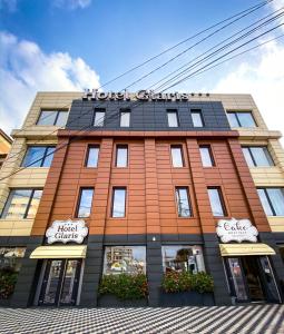 un bâtiment d'hôtel avec un panneau en haut dans l'établissement HOTEL GLARIS, à Tîrgu Frumos