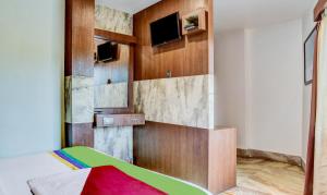 a room with a bed and a tv on a wall at Itsy By Treebo - The Villa Retreat in Siliguri