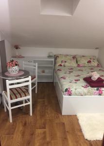 ein kleines Schlafzimmer mit einem Bett und einem Tisch in der Unterkunft Kuća za odmor "Nedeljko"/ Holliday hause "Nedeljko" in Sveti Martin na Muri