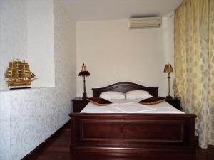 a bedroom with a wooden bed with two pillows on it at Royal Nikita Apartments in Nikita