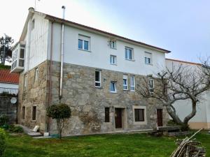 an old stone building with a tree in front of it at Apartamento Rural Sorribos (VUT-CO-004306) in Muros