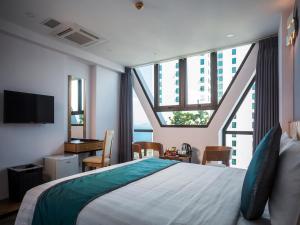 a bedroom with a large bed with a large window at Venue Hotel Nha Trang in Nha Trang